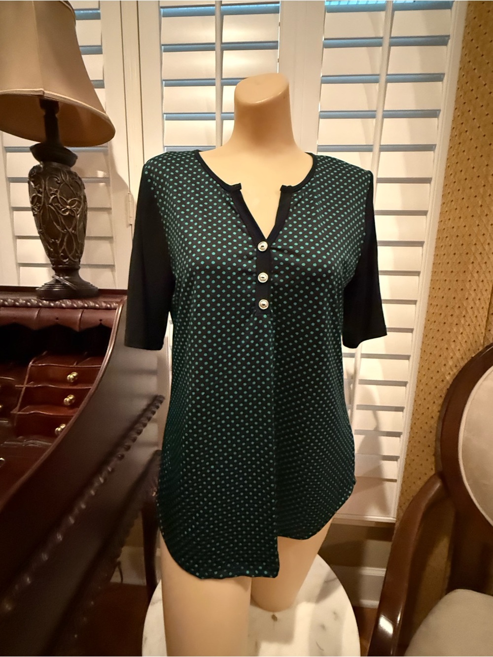 Short sleeve top with interesting neckline. Black with green polka dots on front